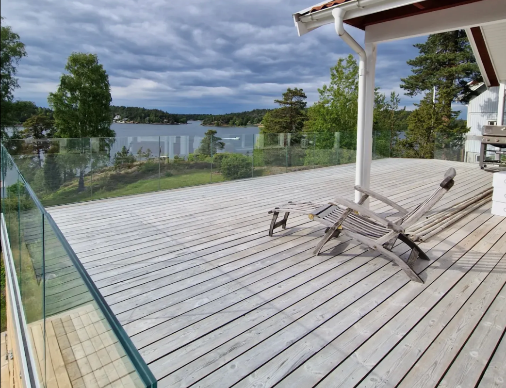 glasräcke runt altan och villa med utsikt