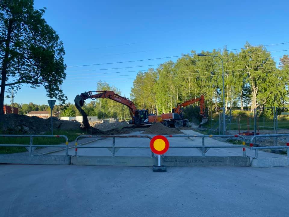 en grävmaskin eller liknande jobbar utomhus mot en blå himmel