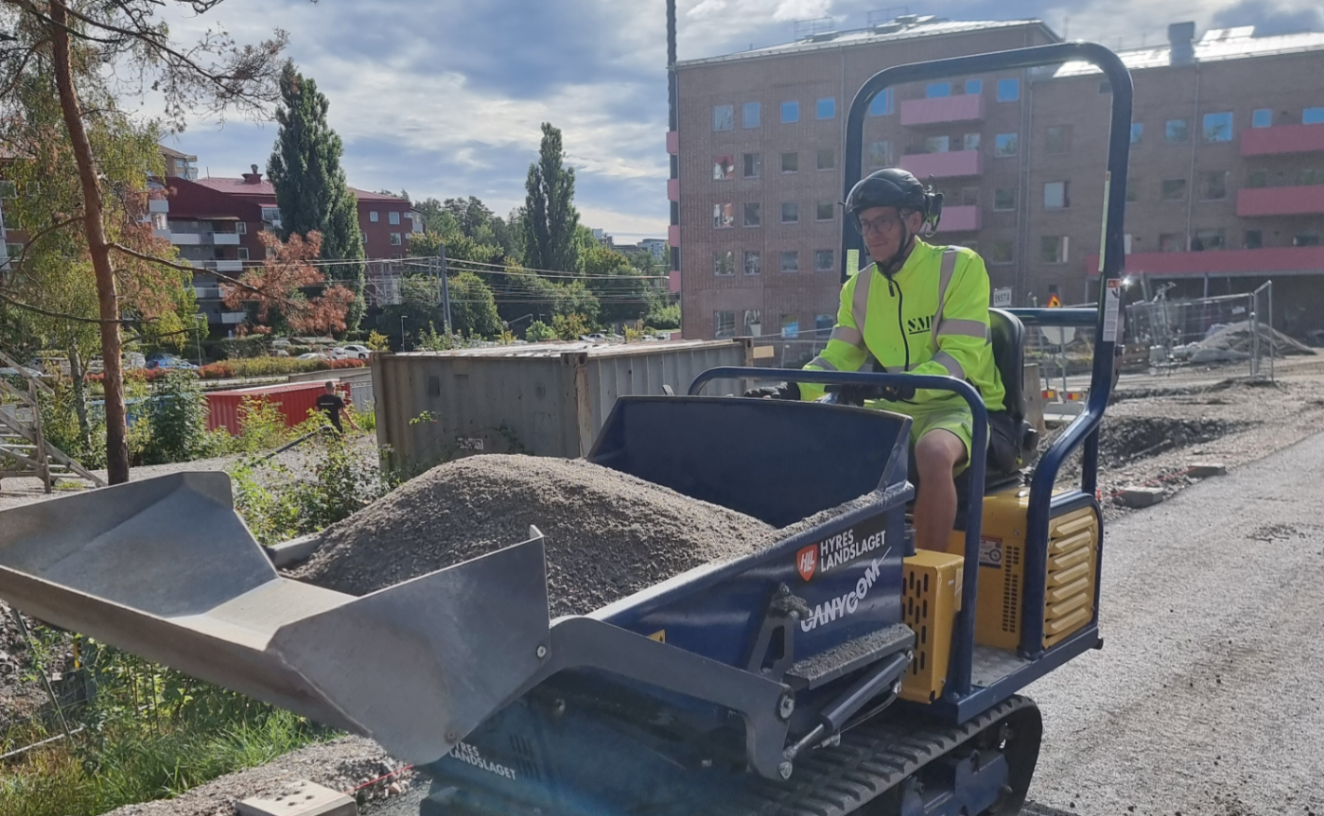 en person åker i fordon med last av grus eller liknande